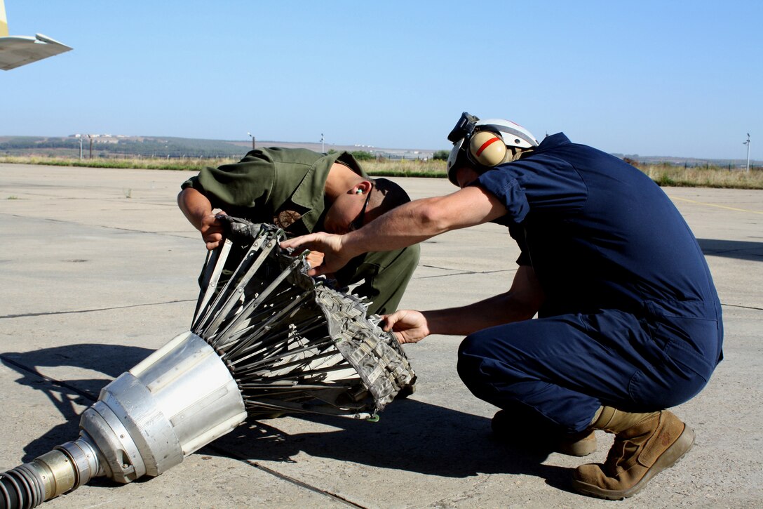 Cpl. Ronald Villarreal [LEFT] and Cpl. Adam Corbin inspect the paradrogue on the tip of a KC-130 aerial refueling hose during routine maintenance here May 31.  Villarreal, of Corpus Christi, Texas and Corbin, of Gainsville, Ga. Are airframes mechanics with VMGR-234, Marine Aircraft Group 41, a 4th Marine Aircraft Wing unit headquartered in Fort Worth, Texas.  The squadron is here for two weeks to train with the Royal Moroccan Air Force as part of Exercise Moroccan Lion.