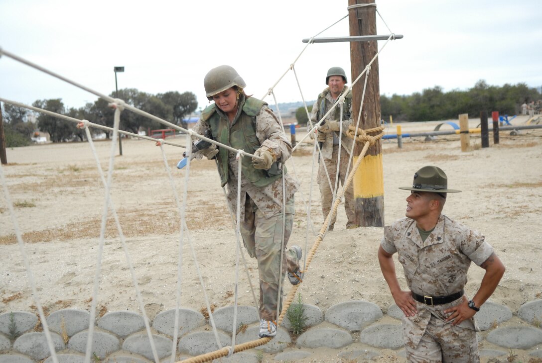 Ashley Boardman, Art teacher, Plymouth High School, Plymouth, Ind., receives encouragement during the bayonet assault course from Sgt. Pedro Lopez, Drill Instructor, 1st battalion, Company C.