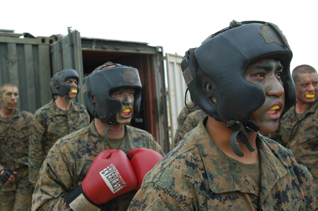 Giovanni Endozo, right, and fellow Platoon 3213 recruits watch as their squad mates face each other one-on-one in the ring as they gear up and wait for their turn to see what they are made of during the body sparring event of the crucible.