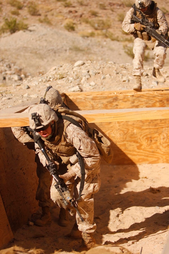 Marines from Company D, 3rd Light Armored Reconnaissance Battalion, invade a trench at Combat Center Range 410 June 9. The range provided them practice integrating their light armored vehicles and dismounted scouts in combat.::r::::n::::r::::n::