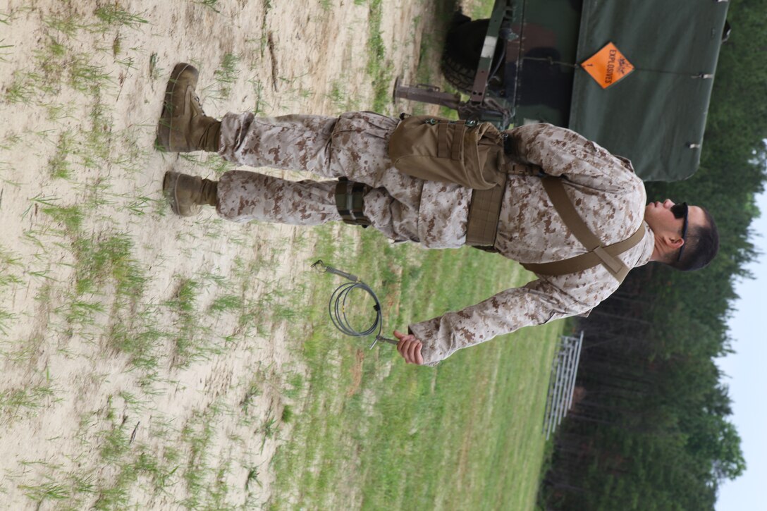 Sergeant Adam Beltram, Explosive Ordinance Disposal, Combat Logistics Group 26, 26th Marine Expeditionary Unit, crimps a cap onto a fuse during a demolitions range at Realistic Urban Training aboard Fort A.P. Hill, Va., June 9, 2010. He does this behind his back because if the cap were to go off, it would send metal shards towards his backside and away from him rather than in his face. This was just one of many courses conducted during the 18-day Realistic Urban Training Exercises the MEU will participate in  as part of its pre-deployment training. The urban environment is among the most challenging tactical environments MEU Marines may face during their scheduled deployment later this fall.