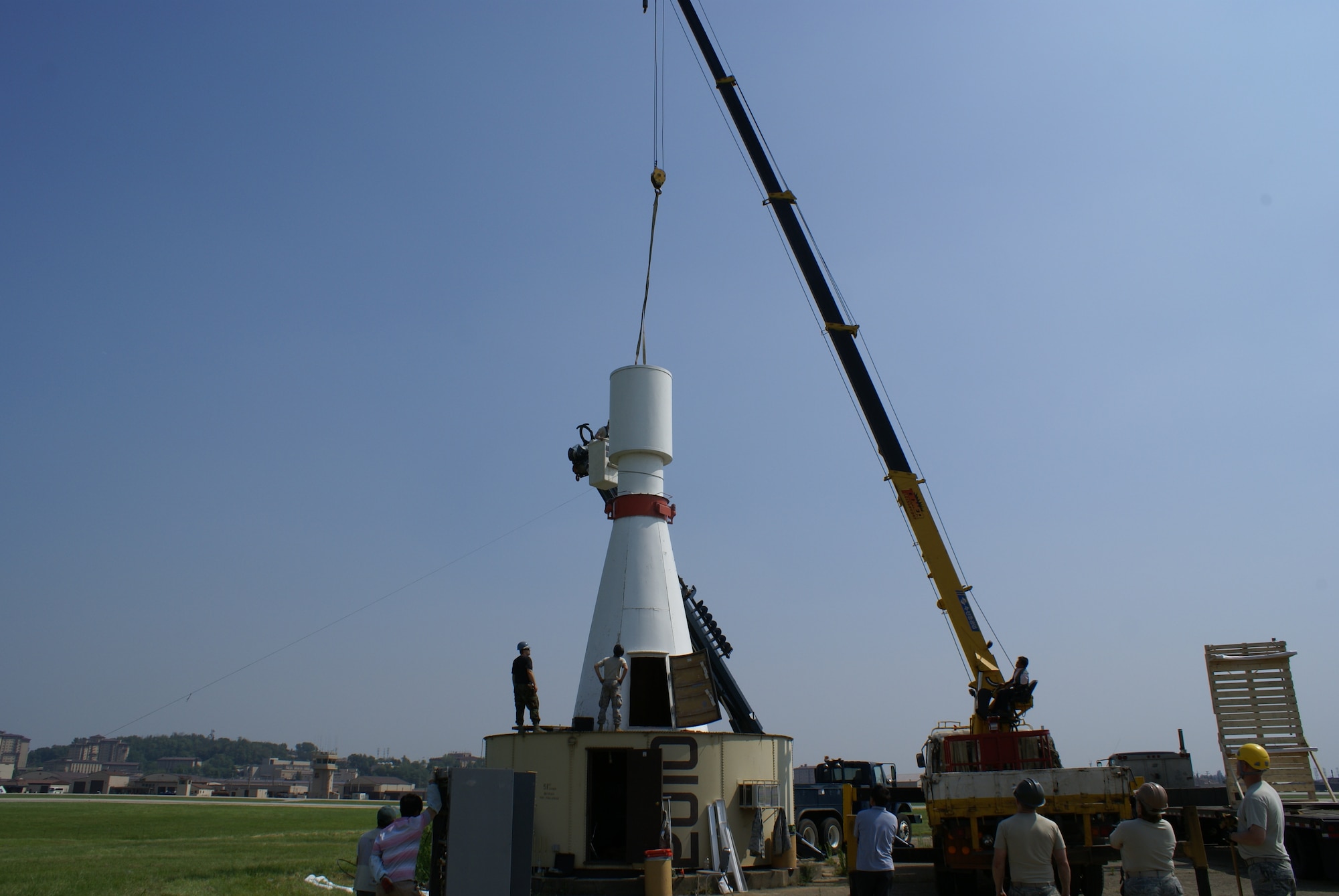 Airmen from the 51st Communications Squadron attach lifting straps and guide ropes in preparation for the removal of the Tactical Air Navigation System, or TACAN, antenna from the Very High Omni-Range radome at Osan Air Base, Republic of Korea, June 4. The antenna was part of the Very High Omni-Range/Tactical Air Navigation System, or VORTAC, used to guide pilots safely to the airfield for approach in adverse weather conditions. The VORTAC was recently decommissioned as a new system was installed and control was turned over to the Republic of Korea Air Force. (Courtesy photo)
