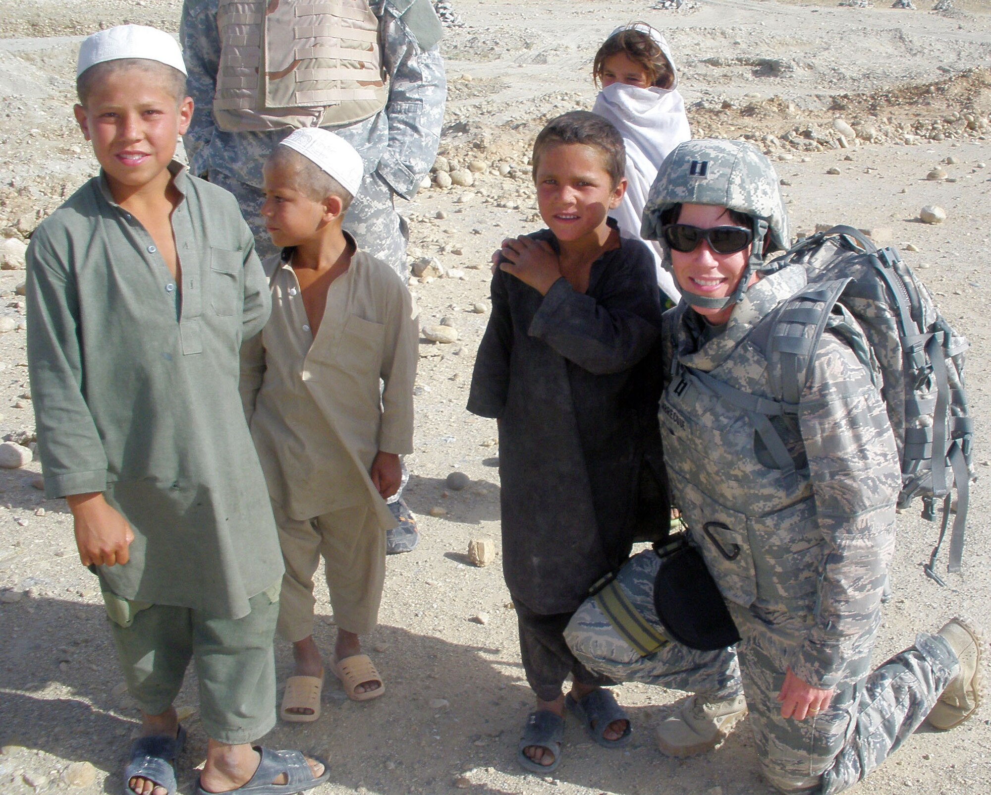 TRAVIS AIR FORCE BASE, Calif. -- Capt. Susan Labrecque, executive officer for the 349th Air Mobility Wing commander here, makes friends with some Afghani children. The captain is deployed to Bagram Air Base, Afghanistan for six months, assigned to the 755th Air Expeditionary Group. Her duties have taken her traveling with a provincial reconstruction team to other locations. She works closely with the U.S. Army and NATO forces in a joint environment. (Courtesy photo)     