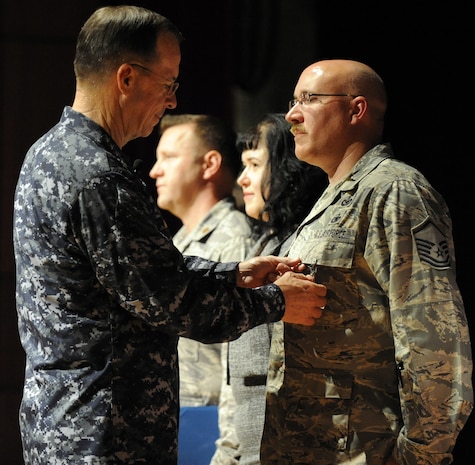 U.S. Navy Adm. Mike Mullen pins a Bronze Star on U.S. Air Force Master Sgt. Sean P. Houlihan at the base theater on Joint Base Charleston, S.C., June 3, 2010. Sergeant Houlihan earned the medal during a recent deployment in support of Operation Enduring Freedom. During his visit, Admiral Mullen fielded questions from Airmen and addressed Department of Defense policy changes and expectations during an all hands call. Admiral Mullen is the Chairman of the Joint Chiefs of Staff, and Sergeant Houlihan is the 628th Air Base Wing Public Affairs superintendent. (U.S. Air Force Photo/James M. Bowman)