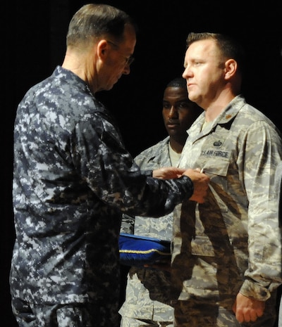 U.S. Navy Adm. Mike Mullen pins a Bronze Star on U.S. Air Force Maj. William Skinner at the base theater on Joint Base Charleston, S.C., June 3, 2010. Major Skinner earned the medal during a recent deployment in support of Operation Enduring Freedom. During his visit, Admiral Mullen fielded questions from Airmen and addressed Department of Defense policy changes and expectations during an all hands call. Admiral Mullen is the Chairman of the Joint Chiefs of Staff, and Major Skinner is the 628th Force Support Squadron operations officer. (U.S. Air Force Photo/James M. Bowman)