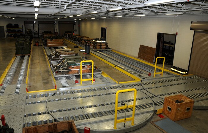 Stage three: The main work area of the Aerial Delivery Facility contains three rows of rolling conveyors. The system provides a fluid transfer of used bundles into the facility for repacking and repair and then finally into storage, allowing for proper bundle rotation. As bundles are used, unused bundles are pushed down the line of rollers and into aerial delivery service. (U.S. Air Force photo/Staff Sgt. Daniel Bowles)