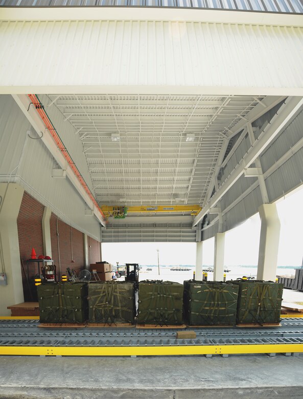 Stage two: An expanded view of the new rear off-loading area reveals ample room for trucks to park during deliveries from North Auxiliary Airfield in North, S.C. A crane places aerial delivery bundles on a rolling conveyor mechanism. The spin of a single roller lasts approximately 20 seconds. (U.S. Air Force photo illustration/Staff Sgt. Daniel Bowles)