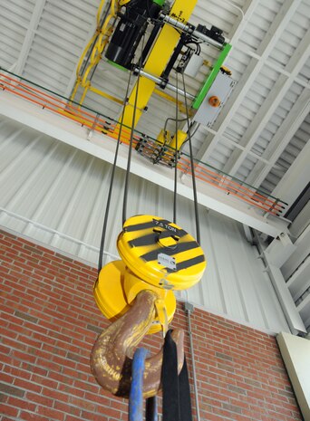 Stage one: The hook and crane is where it all begins. Installed as part of the new rear overhang, the crane skims along a set track to and from off-load trucks, eliminating the need for forklifts used in the previous temporary facility. The crane is now the only one required at the facility, and the ceiling height provides adequate headroom for a safe transfer. (U.S. Air Force photo/Staff Sgt. Daniel Bowles)