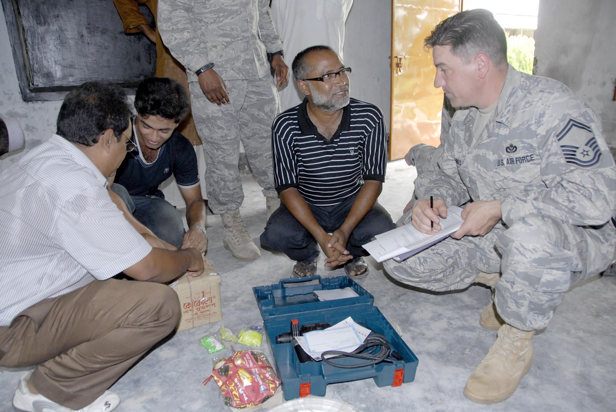 Senior Master Sgt. Terry Rembold (right) discusses engineering plans with a Bangladeshi construction contractor June 9, 2010, in preparation for the kick-off of Pacific Angel in Bangladesh scheduled to take place June 12 through 16, 2010. Operation Pacific Angel is a joint and combined humanitarian assistance operation conducted in the Pacific area of responsibility to support U.S. Pacific Command's capacity-building efforts. Sergeant Rembold is a civil engineer from the 354th Civil Engineer Squadron at Eielson Air Force Base, Alaska. (U.S. Air Force photo/1st Lt. Chris Hoyler)