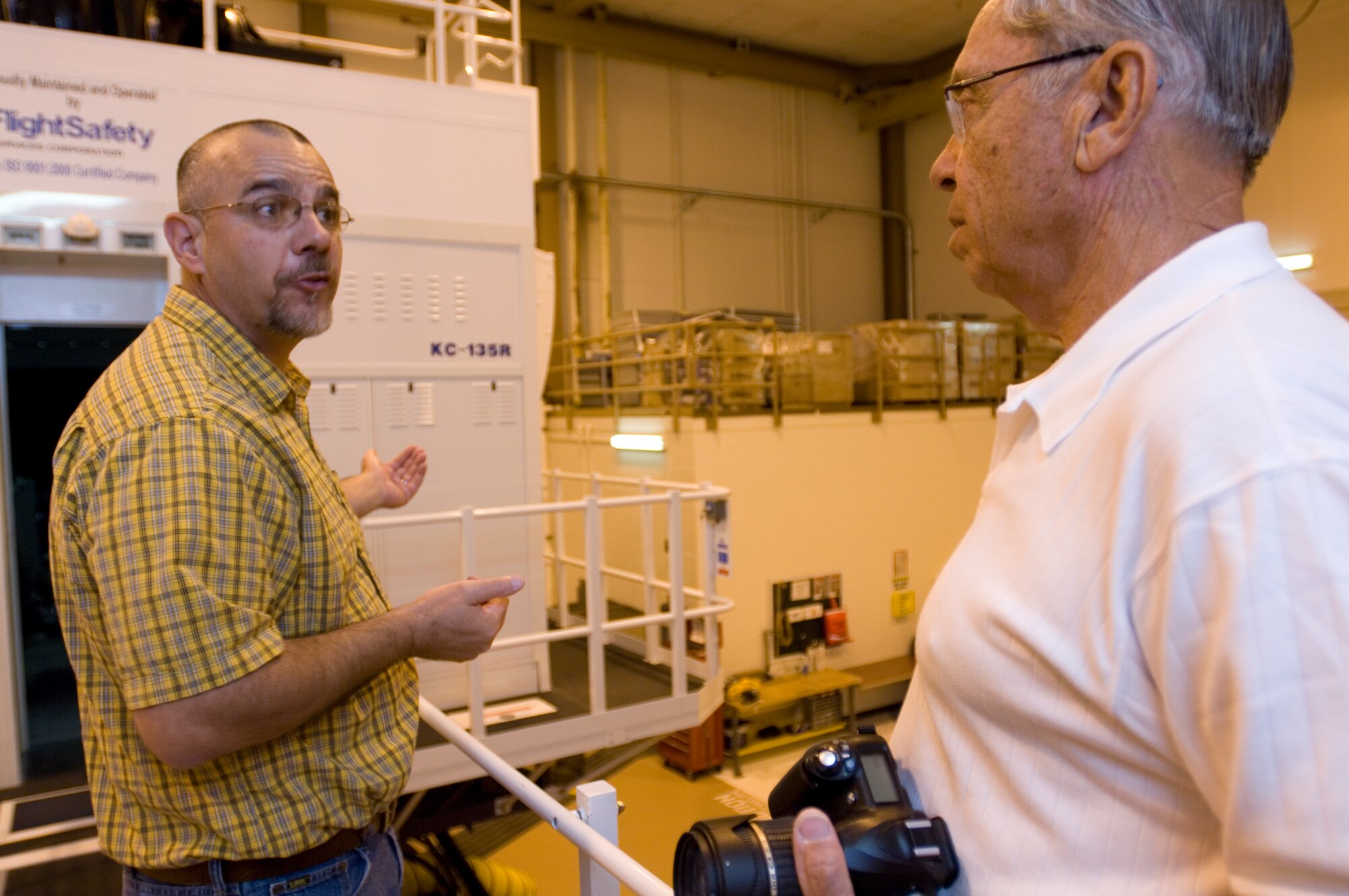 Tim Elia, Flight Safety Services Corporation maintenance supervisor, discusses the features of the KC-135 Stratotanker flight simulator with retired Air Force Brig. Gen. Emiel Bouckaert June 7, 2010, McConnell Air Force Base, Kan.  General Bouckaert toured the simulator during a visit hosted by the Friends of McConnell.  McConnell is the only base Air Force-wide to have three KC-135 simulators.  (U.S. Air Force photo/Senior Airman Abigail Klein)