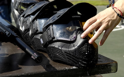 A competitor reaches for a paintball facemask at the base picnic grounds on Joint Base Charleston, S.C., June 4, 2010, for protection against the high speeds the paintballs reach. (U.S. Air Force Photo/Airman 1st Class Lauren Main)