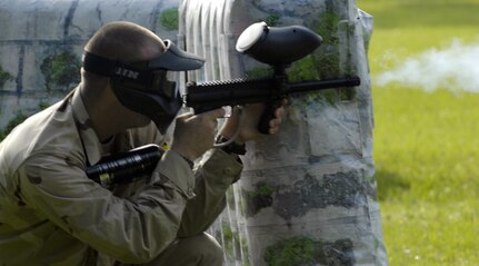 An Airman in the Commander's Fitness Challenge paintball tournament takes aim and fires across the base picnic grounds June 4, 2010, at Joint Base Charleston, S.C. Squadrons represented at the event included the 628th Security Forces, Logistics Readiness, Comptroller, Force Support and 437th Maintenance Squadrons as well as the 437th Operations Group. (U.S. Air Force photo/Airman 1st Class Lauren Main)