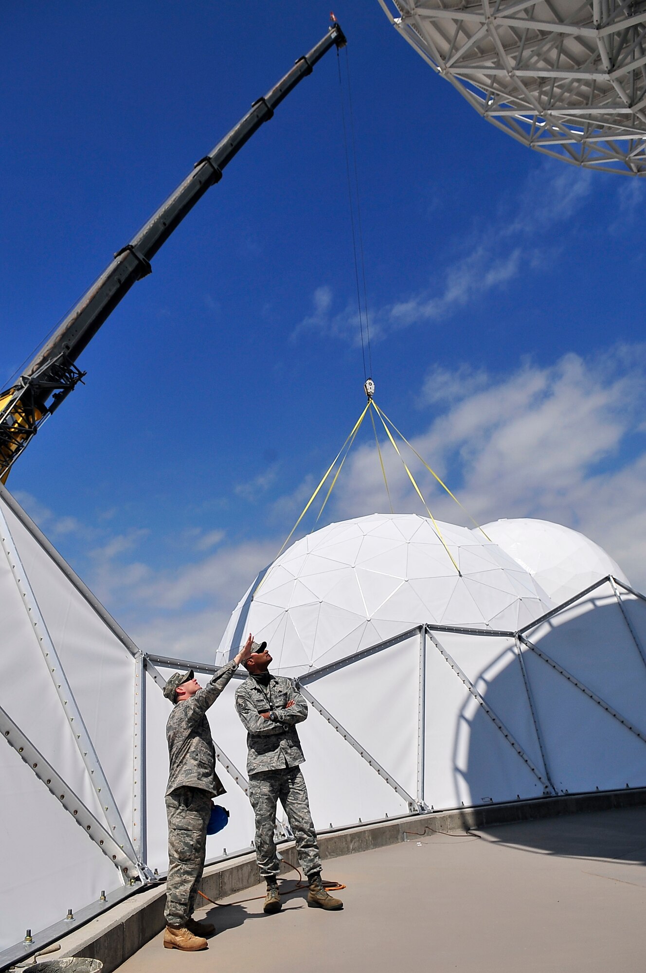BUCKLEY AIR FORCE BASE, Colo. -- Tech. Sgt. Robert Shaw, left, and Senior Master Sgt. Michael Freeman, both of the 460th Space Communications Squadron, do a final site survey before the installation of a radome enclosure here June 9. The enclosure protects Buckley assets from ice, snow and hail during winter weather. (U.S. Air Force photo by Staff Sgt. Kathrine McDowell)
