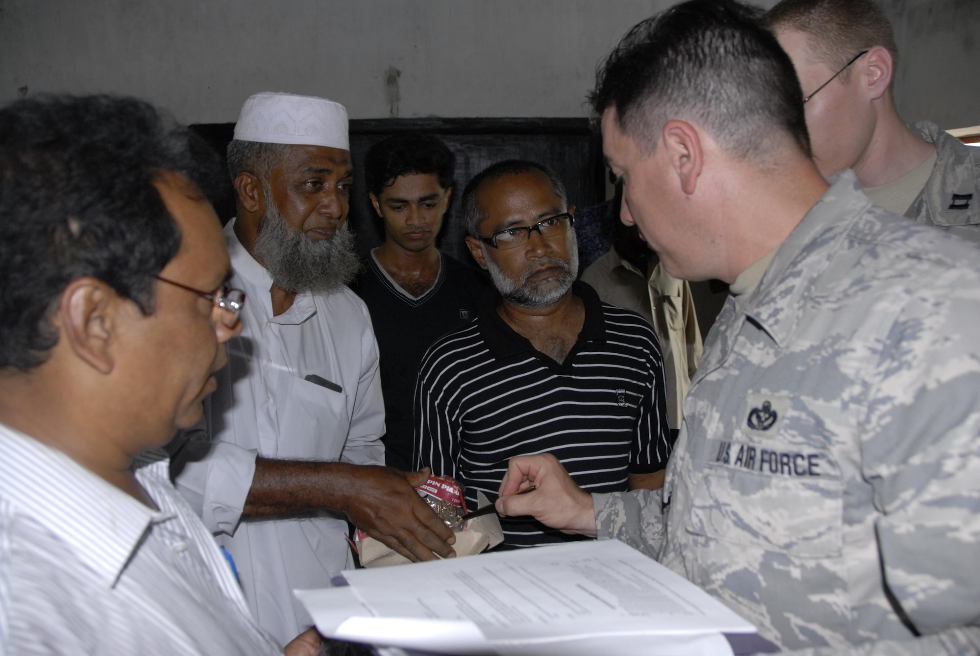 Senior Master Sgt. Terry Rembold (left), a civil engineer from the 354th Civil Engineer Squadron at Eielson Air Force Base, Alaska, discusses engineering plans with Bangladeshi locals as part of Operation Pacific Angel in Bangladesh, on June 9, 2010.  Operation Pacific Angel is a joint and combined humanitarian assistance operation conducted in the Pacific area of responsibility to support U.S. Pacific Command's capacity-building efforts. This humanitarian and civic assistance program is aimed at improving military civic cooperation between the United States and countries throughout the Asia-Pacific region.  More than 55 U.S. military personnel will participate in civil and medical assistance programs with the help of the Bangladesh Air Force and local nongovernmental organizations. The operation is scheduled through June 16.  (U.S. Air Force photo / 1st Lt. Chris Hoyler) 
