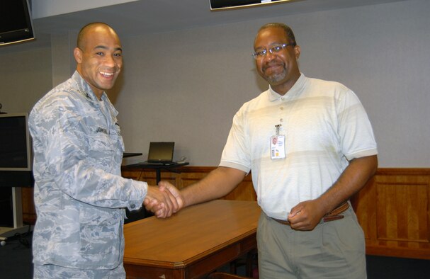 Col. James Johnson, 43rd Airlift Wing, commander presents the Commander’s Coin to Carl Cameron, 43rd AW Legal Office, June 6 in the Pope courtroom. Mr. Cameron works in the legal assistance program where he prepares a wide variety of correspondence, and updates and maintains office records. (U.S. Air Force Photo/1st Lt. Cammie Quinn)