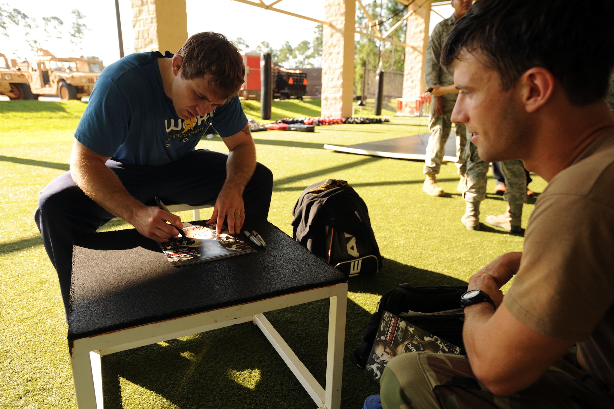 Ultimate Fighting Championship middleweight fighter, Alan "The Talent" Belcher, signs autographs for a Special Tactics and Training Squadron Airman here June 8th, 2010.  Mr. Belcher taught a combatives class for STTS combat controllers going through training here. (U.S. Air Force photo by Senior Airman Matthew Loken) 