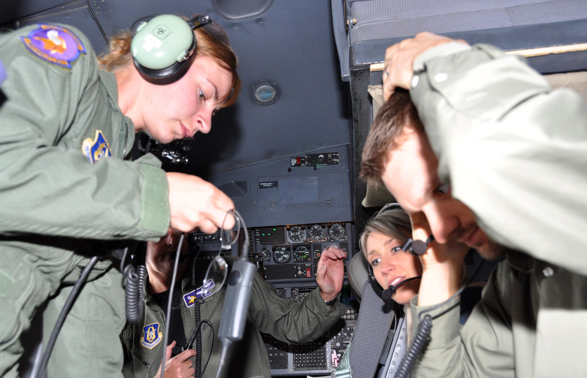 934AW Staff Sgt. Kelly Engel and Lt. Col. Grelong Williams assists congressional staff members Ms. Nicole Serverson, from the office of Rep. Michele Bachman, and Mr. John Paul Yates, from the office of Rep. Erik Paulsen, with their headsets in the cockpit during an orientation flight on June 4 at the Minneapolis - St. Paul ARS. The staffers were able to learn more about the mission of the 934th Airlift Wing, as well as meet the new commander, Col. Darrell G. Young. (U.S. Air Force photo by Tech. Sgt. Scott P. Farley)