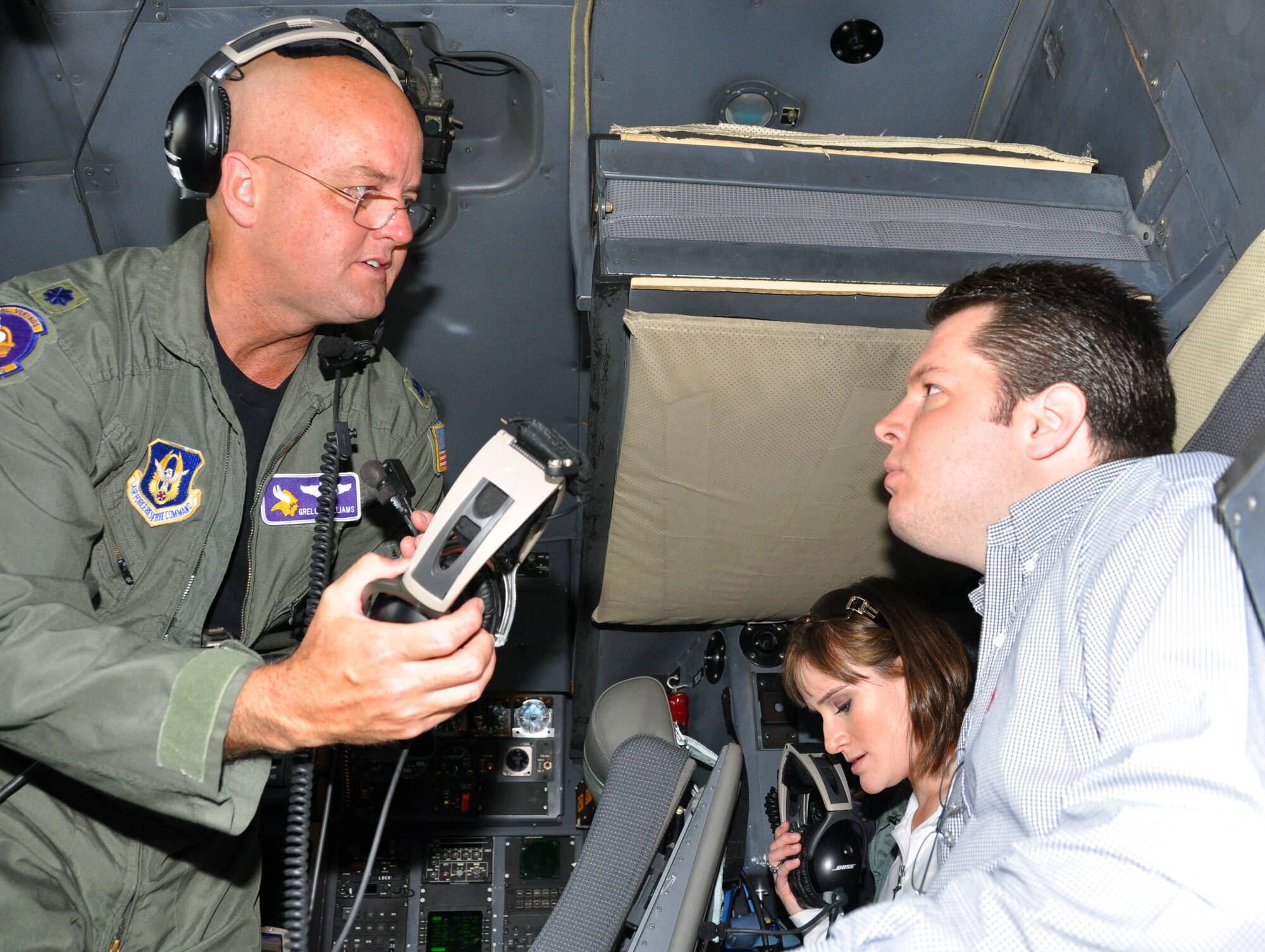 934AW Lt. Col. Grelong Williams assists congressional staff members Mr. Dan Wick, from the office of Rep. Erik Paulsen, and Ms. Rachel Horn, from the office of Rep. Michele Bachman, with their headsets in the cockpit during an orientation flight on June 4 at the Minneapolis - St. Paul ARS. The staffers were able to learn more about the mission of the 934th Airlift Wing, as well as meet the new commander, Col. Darrell G. Young. (U.S. Air Force photo by Tech. Sgt. Scott P. Farley)