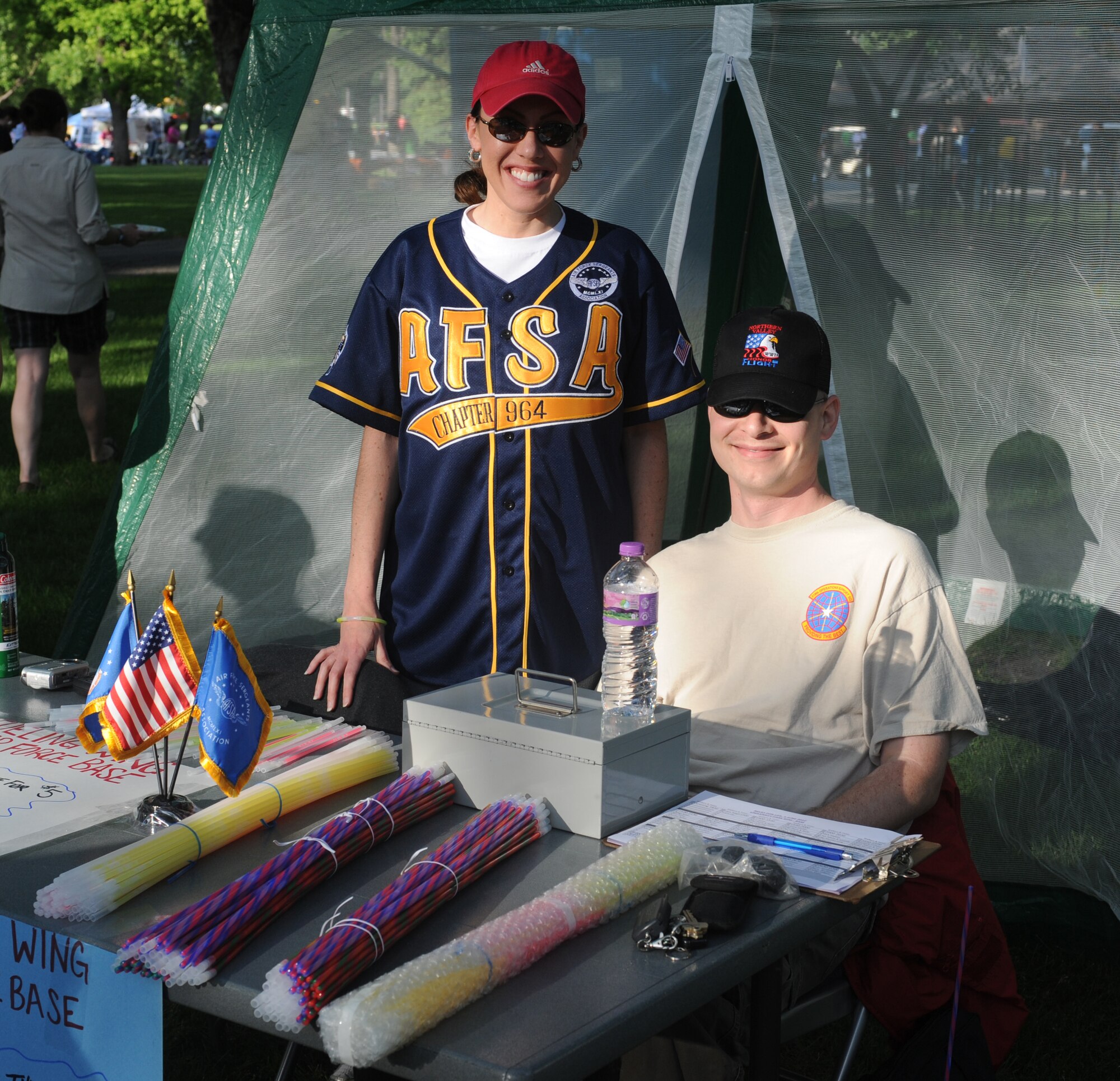 Members from the Air Force Sergeants Association Chapter 964, Grand Forks Air Force Base, pose for a picture while manning a booth selling glow sticks to participants in the American Cancer Society Relay for Life walk at University Park in Grand Forks, June 4. The AFSA chapter sponsored fundraising on base that raised more than $1,000 in support of cancer research. (U.S. Air Force photo by Staff Sgt. Suellyn Nuckolls) 