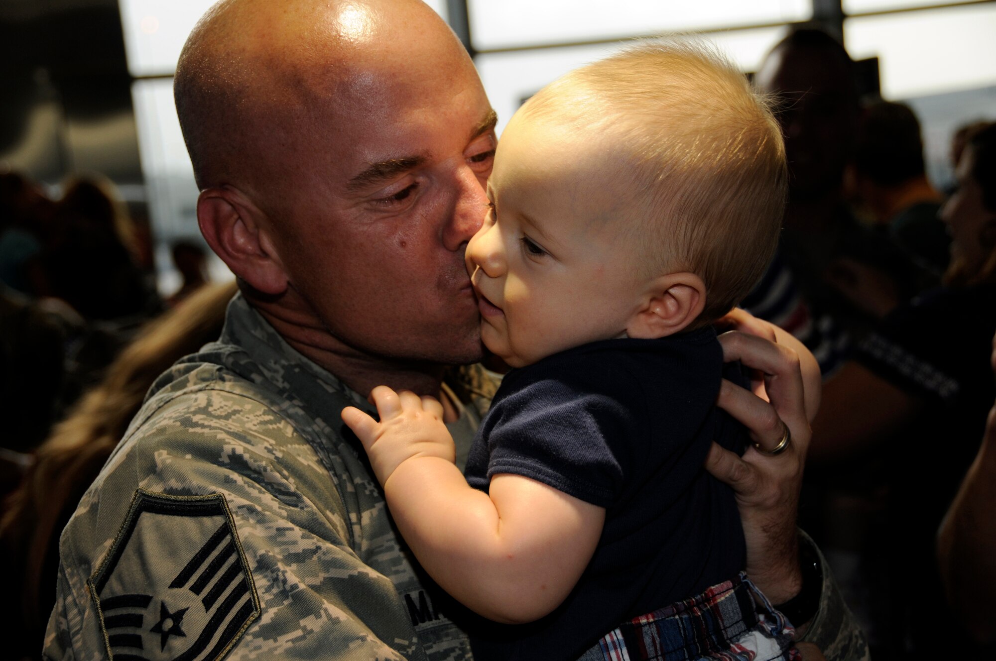 Master Sgt. Chad Martens, 482nd Security Forces Squadron, kisses his infant son after arriving at Miami International Airport on Monday, June 7. Twenty-eight reservists from Homestead Air Reserve Base completed a six-month deployment to Iraq in which they provided security at Kirkuk Regional Air Base. (U.S. Air Force photo/Senior Airman Lou Burton)