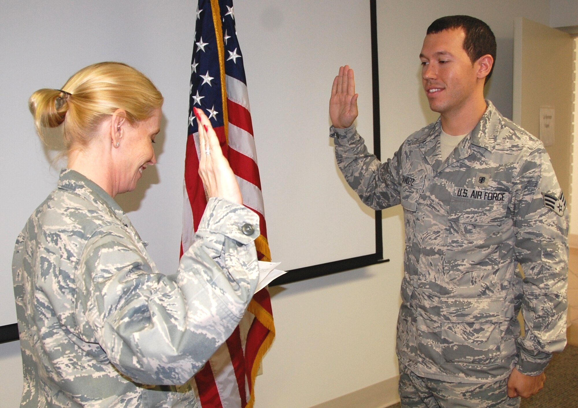 Lt. Col. Abbie Luck, left, 81st Medical Operations Squadron mental health flight commander, administers the oath of office to flight member Senior Airman Thomas Sandoz June 1 in the Arnold Annex conference room.  He’s now a first lieutenant in the Air Force Reserve pending arrival at Maxwell Air Force Base, Ala., in August to attend Commissioned Officer Training.  At that time, he becomes an active-duty officer.  Airman Sandoz recently earned a master’s degree in psychology from the University of Southern Mississippi and was accepted into the Air Force Social Work Program.  Following COT, he will begin a one-year psychology intern/residency program at Eglin AFB, Fla.  He’s been in the Air Force for four years and Keesler was his first assignment.  He entered the service with a bachelor’s degree in psychology from the University of Louisiana-Lafayette.  The Abbeyville, La., native and his wife Krystal, a staff sergeant also assigned to the mental health flight, have a 15-month old daughter, André.  (U.S. Air Force photo by Steve Pivnick)