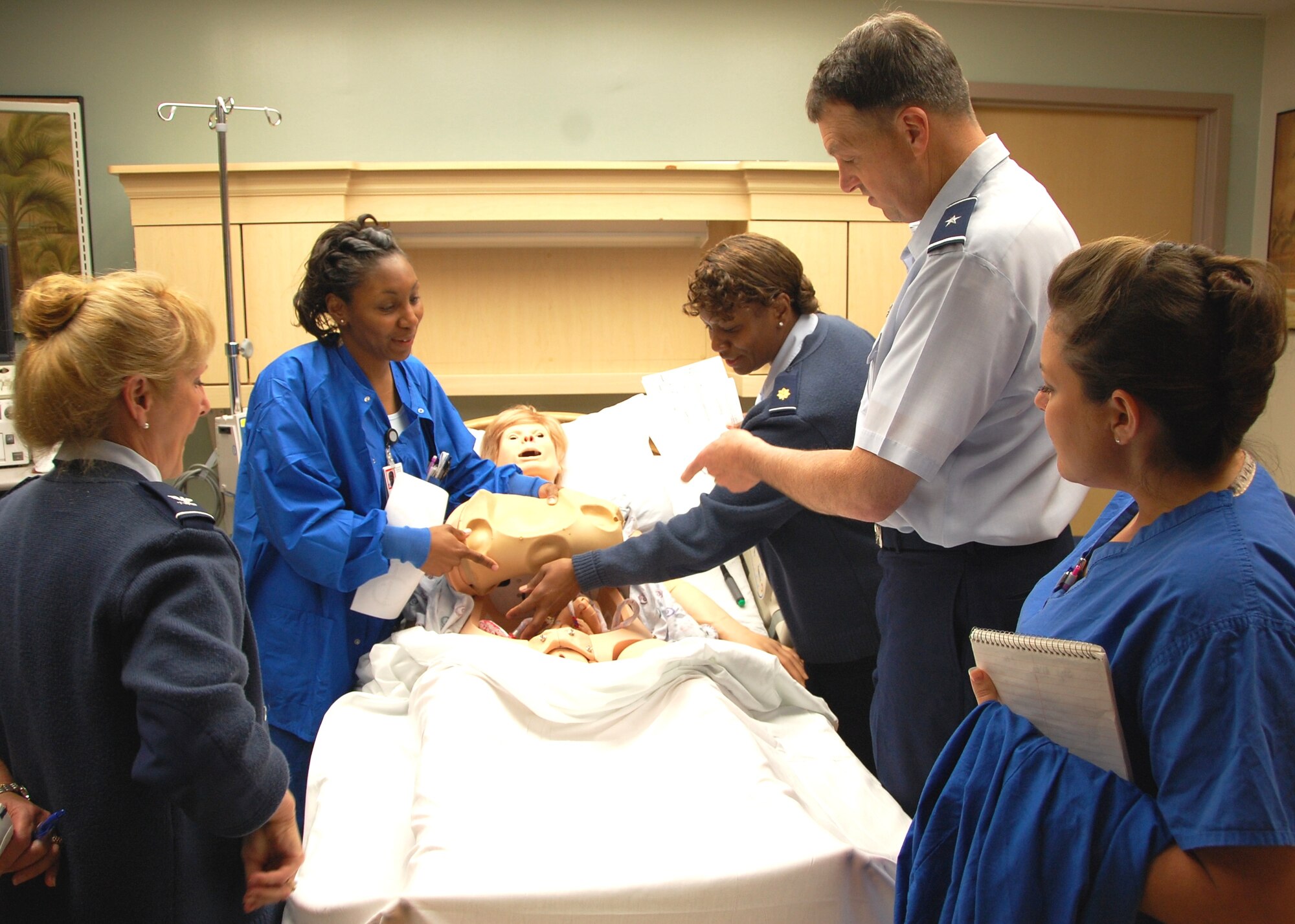 Brig. Gen. (Dr.) Kory Cornum, 81st Medical Group commander, asks about the obstetrics pregnancy simulator in the Keesler Hospital’s Family Birthing Center May 17.  The general, who assumed command April 30, visited 81st Inpatient Operations Squadron areas as part of a series of “immersion” tours of the 81st MDG’s seven squadrons to familiarize him with the hospital’s operation and staff.  Nurse 2nd Lt. Dawn Mitchell, second from left, and Maj. Janice Shealey, maternal child flight commander, explain “Katrina’s” capabilities as Col. Allison Plunk, left, 81st IPTS commander, and Capt. Amber Barker, family birthing center element leader, look on.
(U.S. Air Force photo by Steve Pivnick)