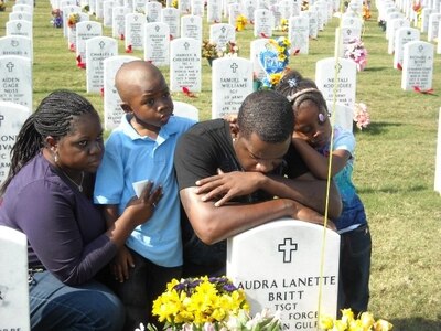 Mourning at the grave of Air Force Tech. Sgt. Audra Britt are, from left, her sister, Anika Lee; her son, Nathaniel Alexander Britt; her brother, Air Force Staff Sgt. Aron Lee; and his daughter, Kennedy Misarah Amaya Lee. Sergeant Britt and her husband, Tech. Sgt. Maurice Britt, died at the hands of a drunk driver in 2009. (Courtesy photo)