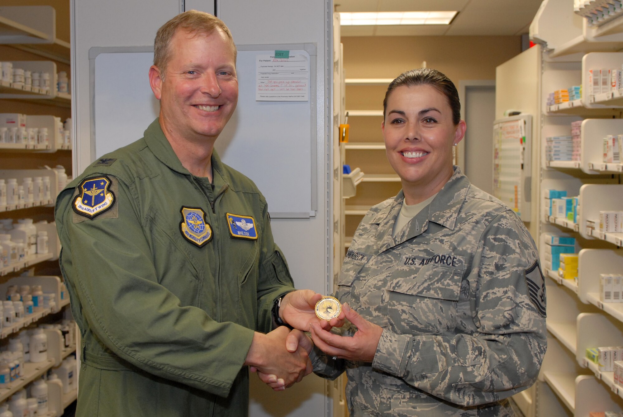 Col. Michael Zick, 19th Airlift Wing vice commander, presents Master Sgt. Amber Aschenbeck, 19th Medical Support Squadron pharmacy flight chief, with a Black Knights coin June 4 for being the Combat Airlifter of the Week at the pharmacy on base. Sergeant Aschenbeck managed a $285,000 project at the pharmacy, ensuring better customer service and timeliness with patients seen at the medical group. (U.S. Air Force photo by Senior Airman Steele C. G. Britton)
