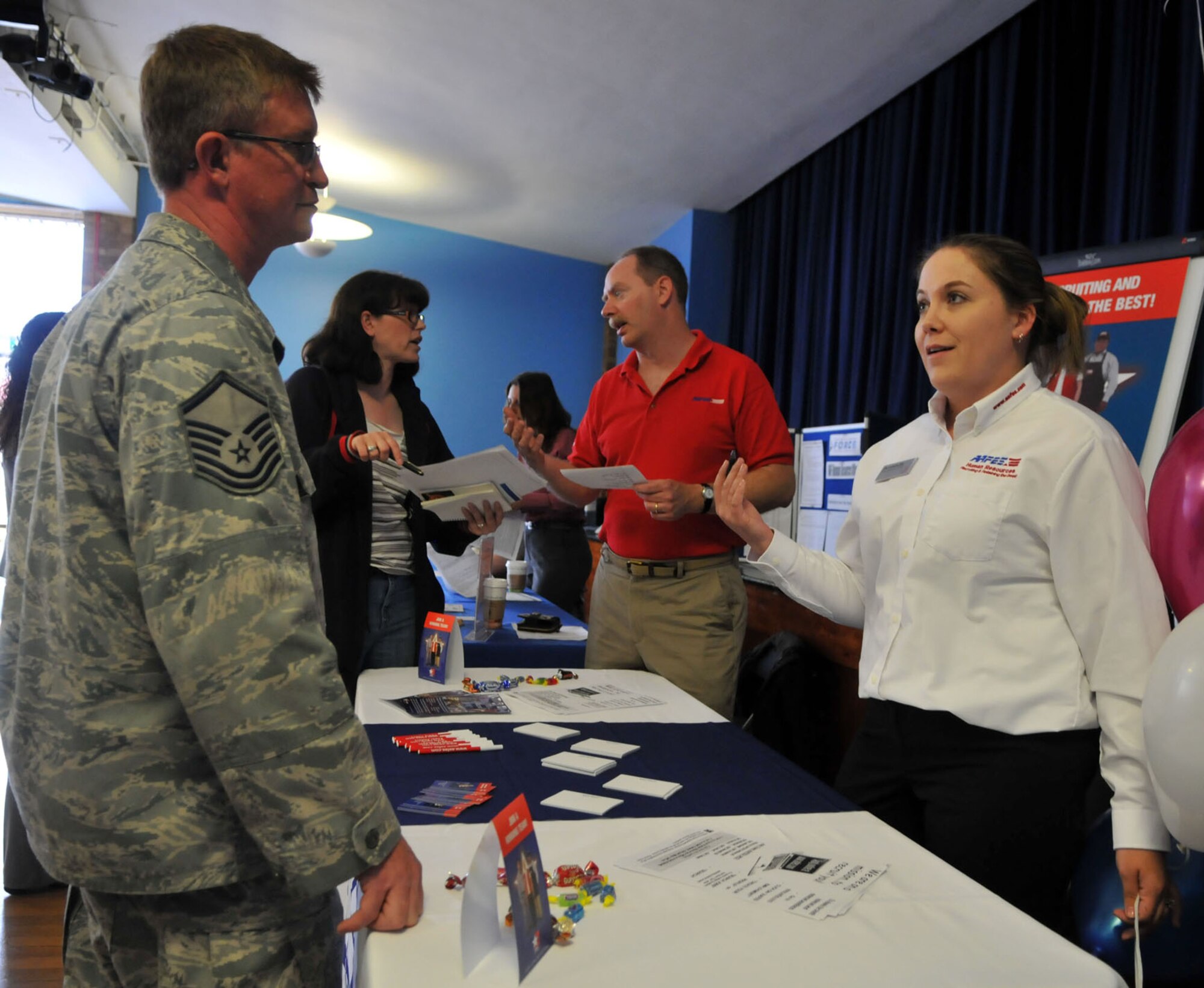 RAF MILDENHALL, England -- Master Sgt. John Kinser, 100th Maintenance Operations Squadron, talks to Amanda Cameron, Army and Air Force Exchange Service, about job opportunities within her company at a career fair June 9.  Several recruitment agents gathered at the Bop Hope Community Center to talk with potential employees about the various aspects of their jobs.  (U.S. Air For photo/Staff Sgt. Austin M. May)