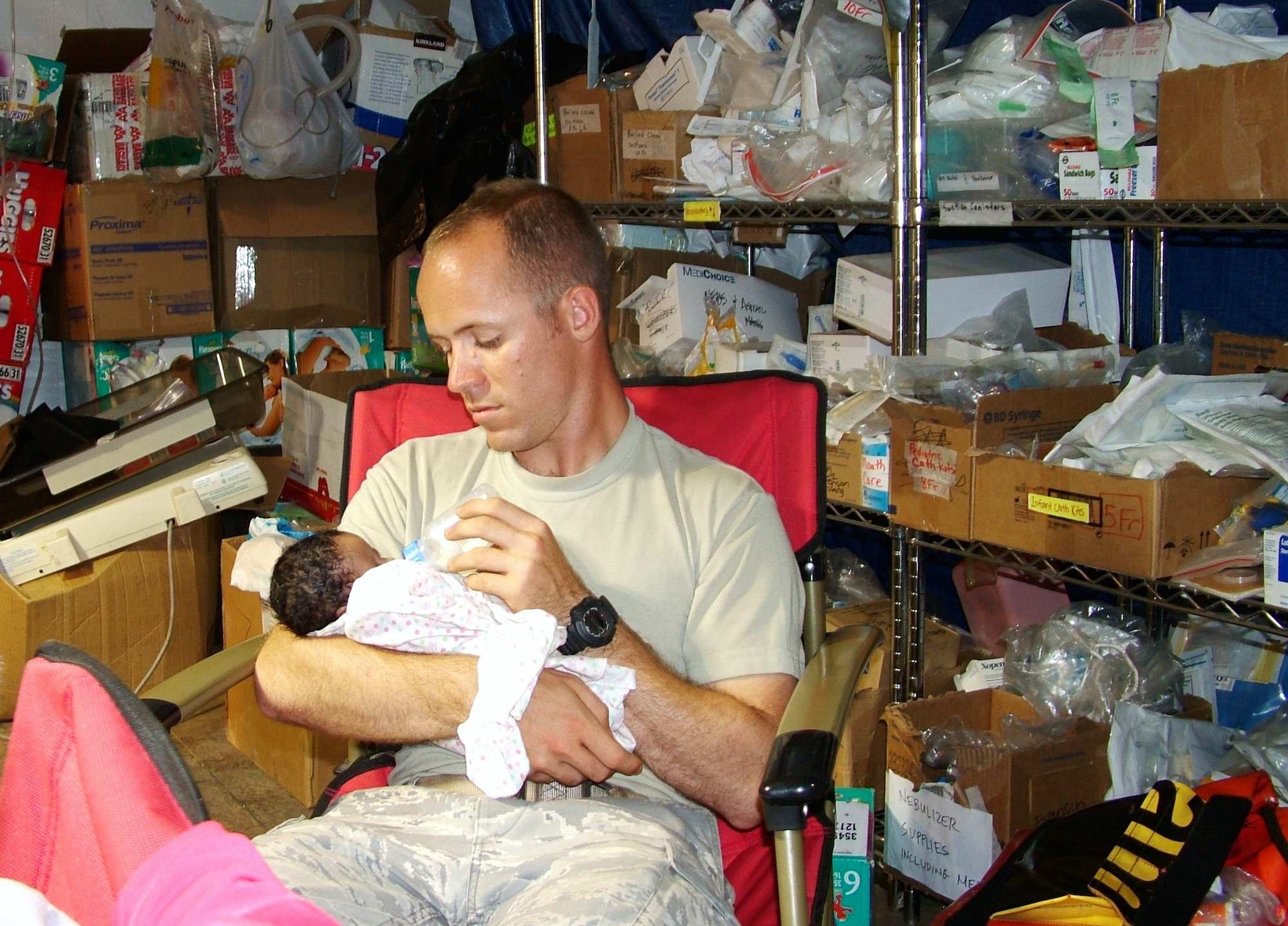 First Lt. Michael Capra, 3rd Combat Communications Support Squadron, Tinker Air Force Base, Okla., cares for a baby at the University of Miami Hospital, Port-Au-Prince airport location. Members of the 3rd Combat Communications Group were supporting relief efforts in Haiti since February and the last remaining members returned home in June. (US Air Force photo)
