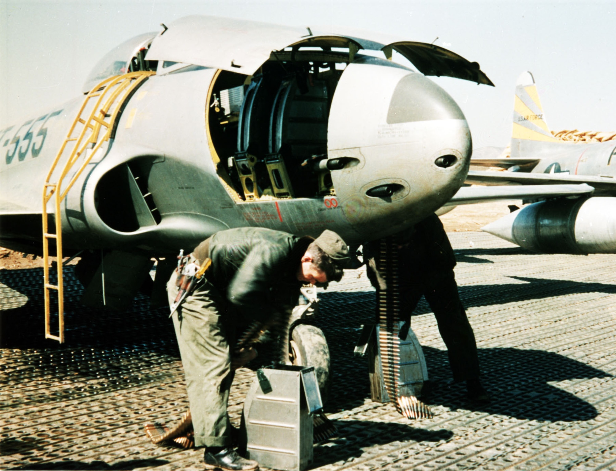 Armorers loading the six .50-cal. machine guns of an F-80C. (U.S. Air Force photo)