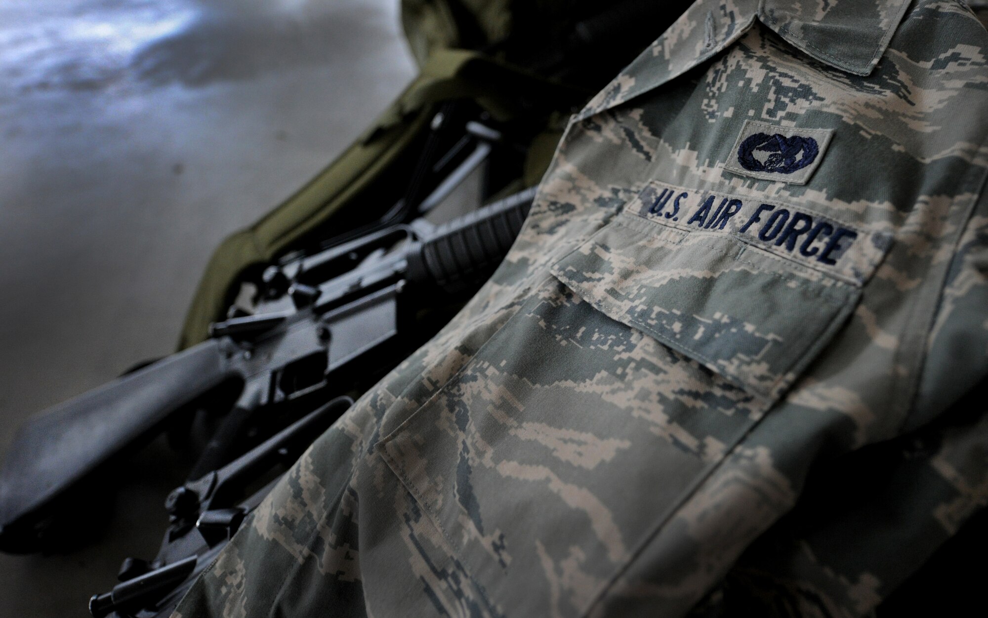 JOINT BASE MCGUIRE-DIX-LAKEHURST, N.J. – An Airman battle uniform blouse rests on an issued weapon at the 621 Contingency Response Wing’s Global Reach Deployment Center here June 2. The 621st CRW was deploying to northern Afghanistan in support of the logistic surge for Operation Enduring Freedom and specializes in providing short notice worldwide air mobility ground support in remote or austere locations.  (U.S. Air Force photo/Tech. Sgt. Parker Gyokeres/released)