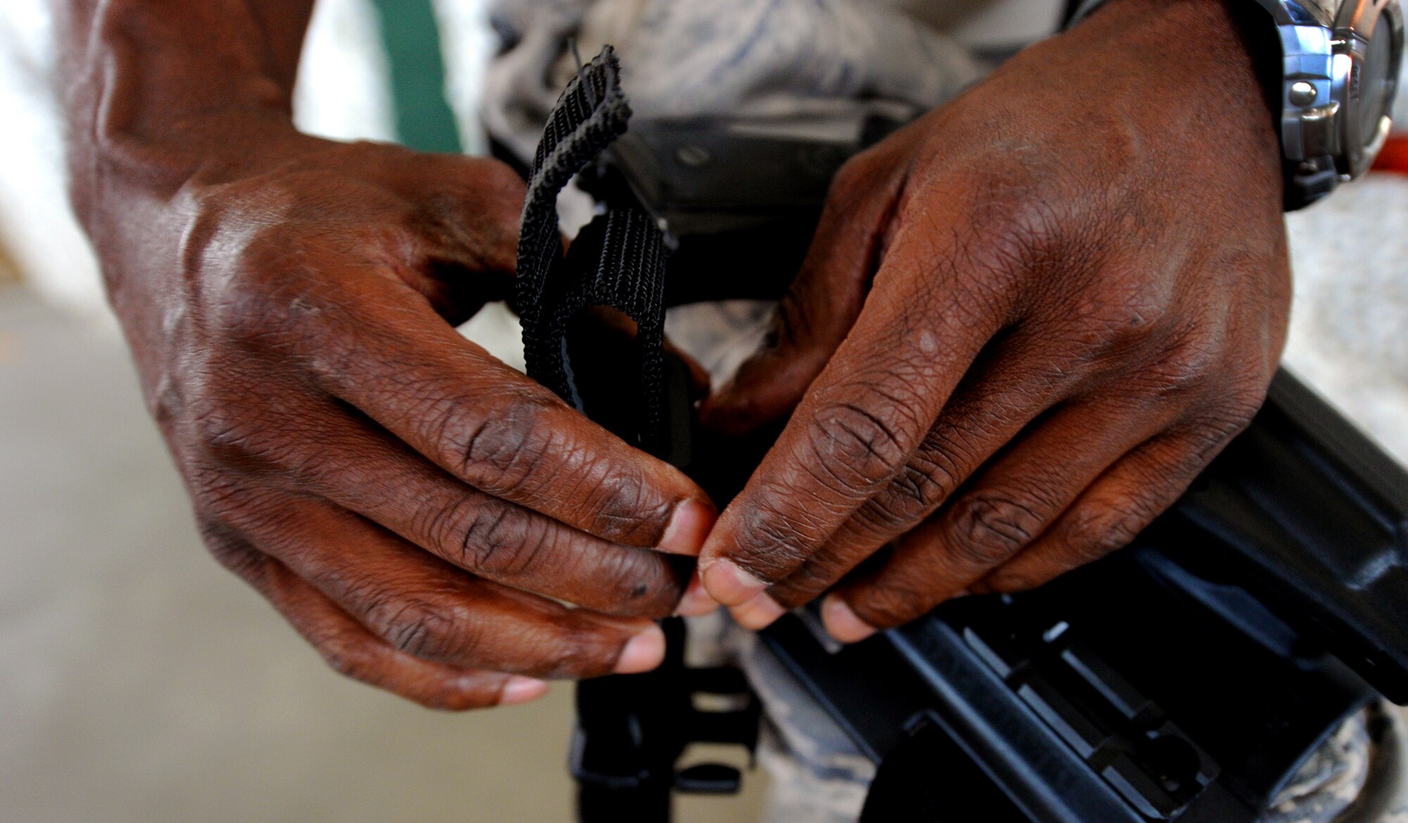 JOINT BASE MCGUIRE-DIX-LAKEHURST, N.J. – Master Sgt. Valmond Hope, 819th Global Support Squadron ramp operations coordinator, adjusts the straps on his drop-leg pistol holster at the 621 Contingency Response Wing’s Global Reach Deployment Center here June 2. Sergeant Valmond and his team were deploying to provide special cargo handling support for the Operation Enduring Freedom logistic surge. (U.S. Air Force photo/Tech. Sgt. Parker Gyokeres/released)