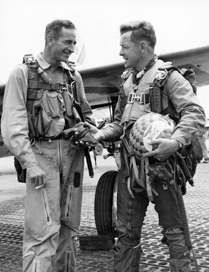 Upon completing his 100th and final mission in F-84 Thunderjets, Col. Victor Warford (left), 58th Fighter Bomber Wing (Reinforced) commander, hands over his gun to his deputy, Col. Joseph Davis Jr. (U.S. Air Force photo)