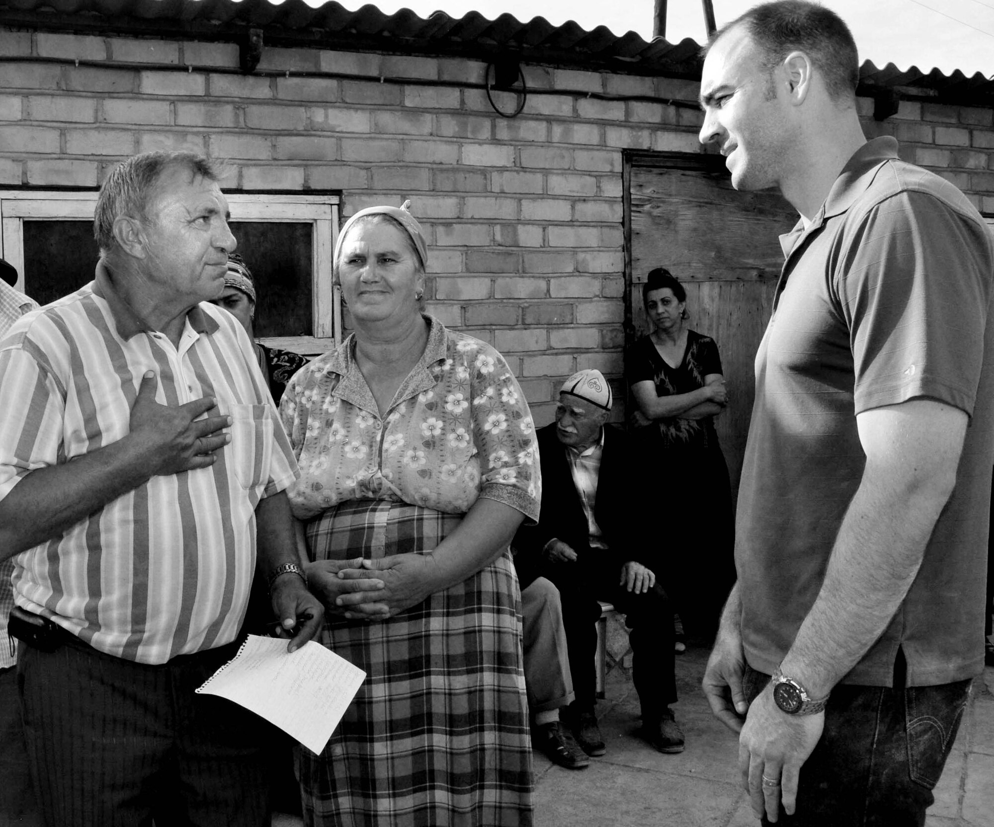 Konstantin Aleksanrovich Kucherov, deputy director of potable water supply for Maevka Village, Kyrgyzstan (left), thanks Maj. Shane Hamacher, the humanitarian assistance director for the Transit Center at Manas, for $10,000 worth of household goods Airmen purchased on the local economy June 7, 2010, for villagers whose homes were damaged or destroyed during the revolution here April 7, 2010. (U.S. Air Force photo/Staff Sgt. Carolyn Viss)