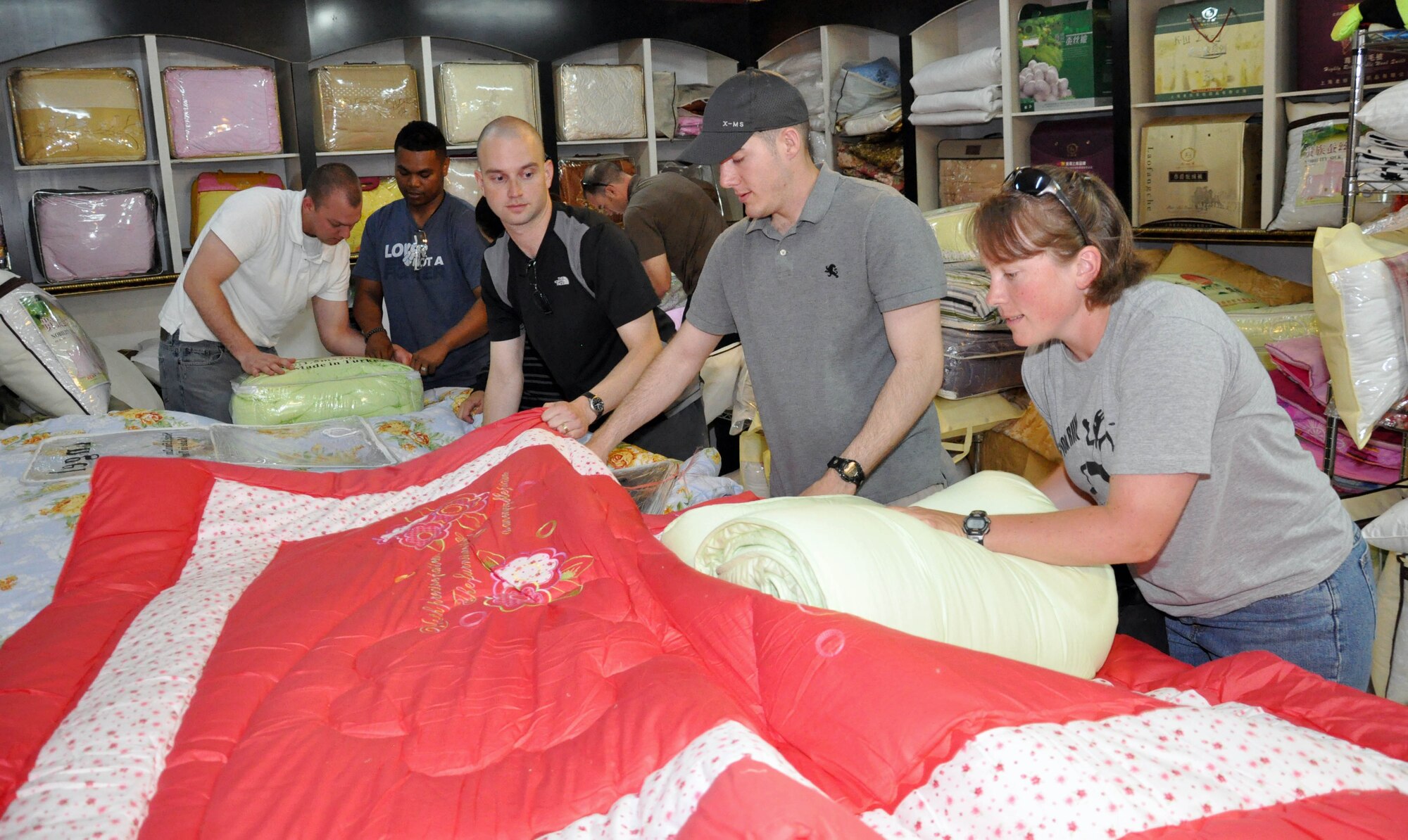Airmen from the Transit Center at Manas, Kyrgyzstan, shop for and package more than 60 blankets and sets of sheets purchased on the local economy June 7, 2010, for people of Maevka Village who lost all their household goods during the revolution in Kyrgyzstan April 7, 2010. (U.S. Air Force photo/Staff Sgt. Carolyn Viss)