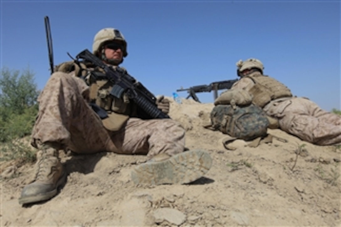 U.S. Marine Corps Sgt. Steven Forrester and Lance Cpl. Ian Papworth, both with Weapons Company, 3rd Battalion, 1st Marine Regiment, 1st Marine Division, provide security while other Marines cross a canal near Patrol Base Karma in Helmand province, Afghanistan, on May 13, 2010.  