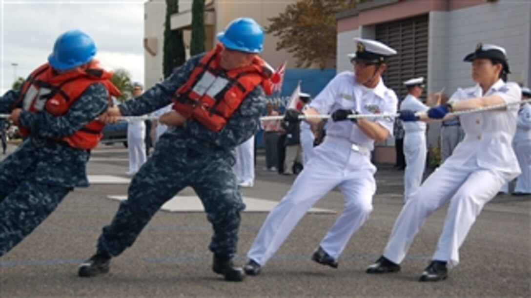 U.S. Navy Seaman Colton Sears (left) and Petty Officer 2nd Class Aaron Boyer, both assigned to USS Lake Erie (CG 70), work alongside Japanese navy Petty Officer 3rd Class M. Ueno and Leading Seaman Kaho Nishimura (right), both assigned to JS Kashima (TV 3508), as they set the brow in place during the Kashima’s arrival in Pearl Harbor, Hawaii, on June 8, 2010.  Members of the Japanese Maritime Self-Defense Force are in the area to participate in various professional exchanges and social events with their U.S. counterparts.  This year marks the 50th anniversary of the U.S.-Japan Treaty of Mutual Cooperation of Security of 1960 that established the alliance between the two countries.  