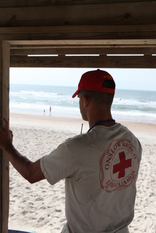 Cpl. William Hutton, a chief lifeguard with the beach detachment, Company A, Headquarters and Support Battalion, Marine Corps Base Camp Lejeune, and a rifleman with 1st Battalion, 8th Marine Regiment, 2nd Marine Division, scans the shoreline of Onslow Beach, June 10.  Onslow Beach lifeguards conduct rescue missions and enforce rules to ensure the safety of all beach patrons.