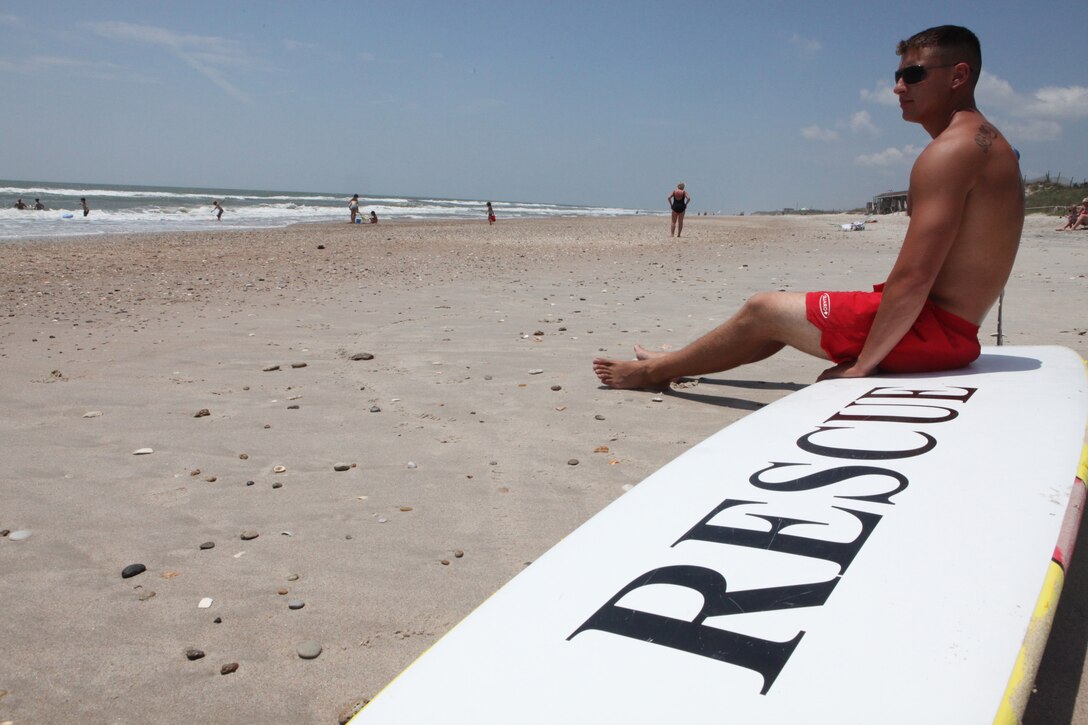 Cpl. Rick McAdon, a squad leader with the beach detachment, Company A, Headquarters and Support Battalion, Marine Corps Base Camp Lejeune, and a rifleman with 2nd Battalion, 8th Marine Regiment, 2nd Marine Division, watches the waters of the enlisted section of Onslow Beach, June 10.  Onslow Beach lifeguards, many of whom recently returned from combat missions overseas, help save lives on the homefront by being the eagle eyes of the sea and enforcers of the beach laws.