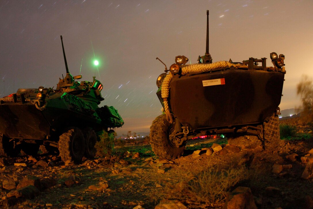 Light armored vehicles from Company D, 3rd Light Armored Reconnaissance Battalion are illuminated by flares at the Combat Center’s Range 410 June 10. The LAVs were used along with dismounted scouts to conduct platoon sized attacks at the range June 9 to 11.::r::::n::