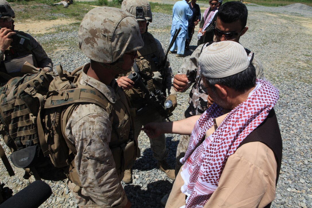 A corpsman with 1st Platoon, Company K, Battalion Landing Team 3/8, 26th Marine Expeditionary Unit, takes a look at a rash on the arm of a role-playing villager during cultural awareness training at Realistic Urban Training at Fort A.P Hill, Va., June 10, 2010. The Marines came to the village to meet with community elders and find out what needs the community had. This was just one of many courses conducted during the 18-day Realistic Urban Training Exercises the MEU will participate in as part of its pre-deployment training. The urban environment is among the most challenging tactical environments MEU Marines may face during their scheduled deployment later this fall.