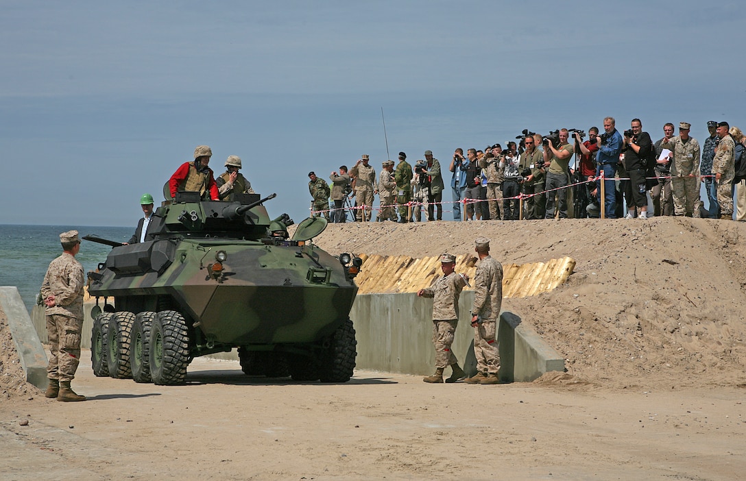 Latvian President Valdis Zatlers (in red on top of vehicle) rides a Light Armored Reconnaissance Vehicle through the beach entry access point constructed to aid maritime preposition force offload exercises and increase access to local recreation areas here. President Zatlers visited the Marines and Sailors of 4th Landing Support Battalion and Naval Beach Group 2, who have been working together with Latvian forces to conduct maritime preposition force offload operations and other training events here since the start of the exercise June 6.