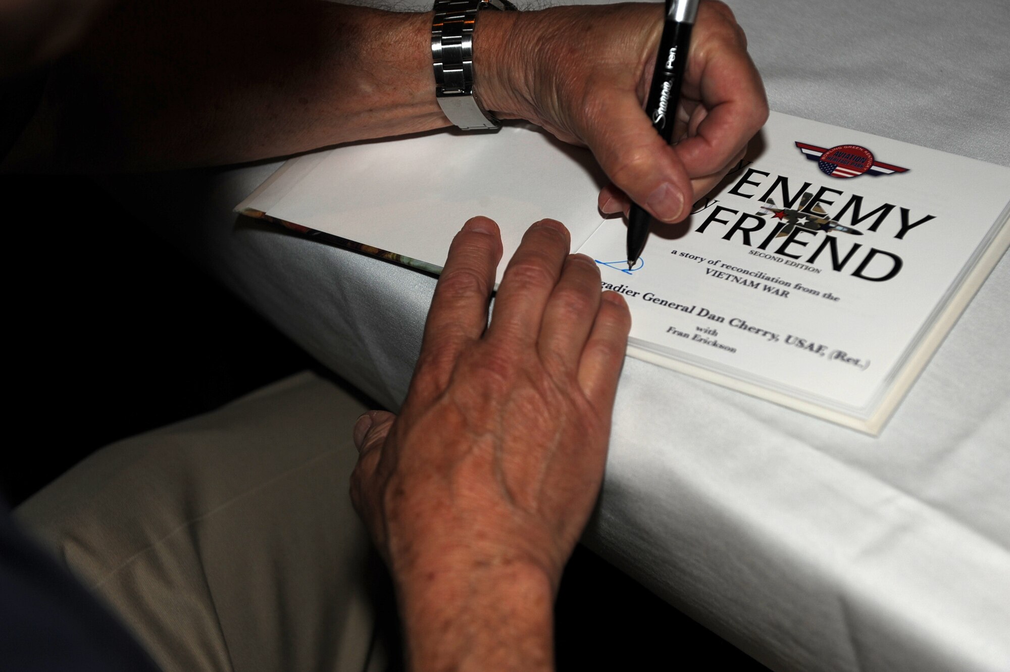 SEYMOUR JOHNSON AIR FORCE BASE, N.C. -- Retired Brig. Gen. Dan Cherry signs a copy of his book titled “My Enemy….My Friend” here June 4, 2010. General Cherry, along with former Vietnamese pilot Nguyen Hong My, hosted a book signing and presentation following their tour of the base. General Cherry hails from Bowling Green, Ky. (U.S. Air Force photo/Senior Airman Gino Reyes)
