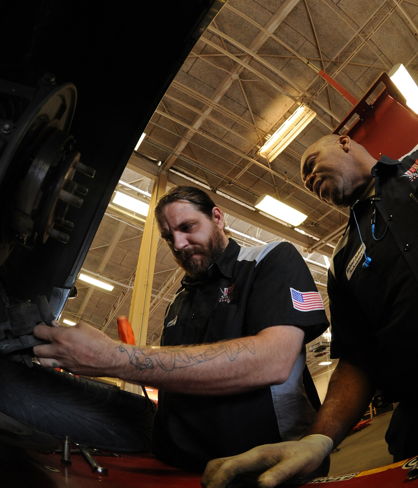 MOODY AIR FORCE BASE, Ga. --Michael Jackson and Jason Huard, Auto Skillz Center automotive technicians, work together on removing on a broken brake caliber here May 26. The Auto Skillz shop allows members to drop off their vehicles with the technicians and pay to have minor automotive work done. (U.S. Air Force photo by Airman 1st Class Benjamin Wiseman/RELEASED)