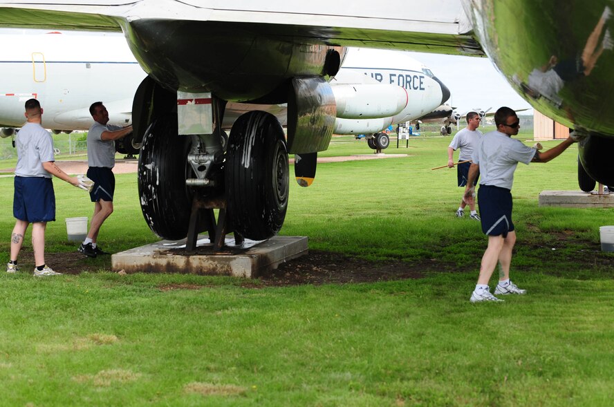 Members of the 28th Munitions Squadron clean a B-29 Superfortress static display at the South Dakota Air and Space Museum, June 4. The Squadron uses sponges to scrub, and a pressure washer to rinse during the cleaning as part of the Adopt-a-Plane program. (U.S. Air Force photo/Airman 1st Class Corey Hook)