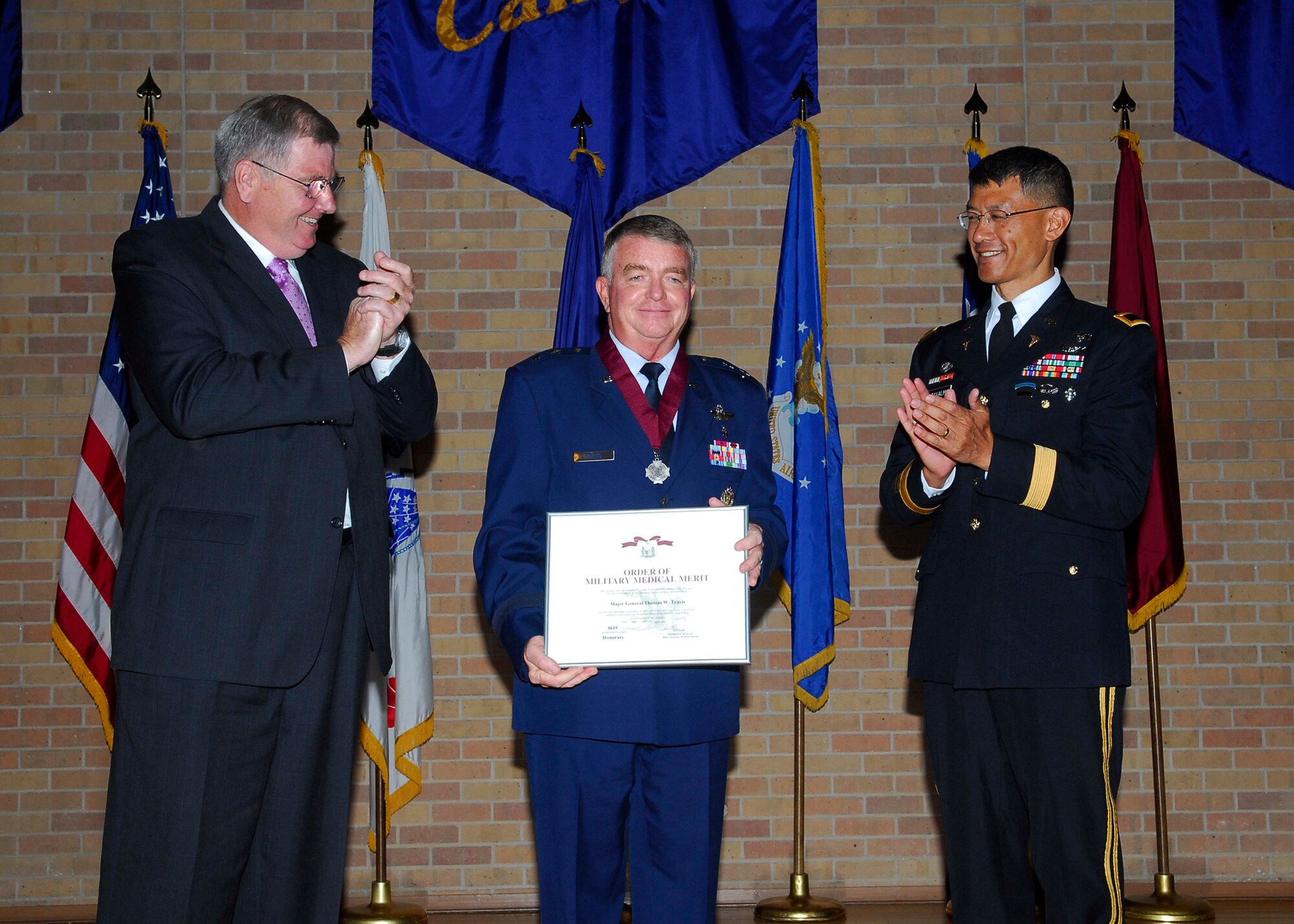 Retired Army Maj. Gen. Patrick D. Sculley, president of the Order of the Military Medical Merit, (left) and Brig. Gen. Joseph Caravalho, Jr., commander, Brooke Army Medical Center, (right) welcome Maj. Gen. Thomas W. Travis into the ranks of the elite Army medical organization June 4 in San Antonio, Texas.  Members of other military Services who have made distinguished contributions to the Army Medical Department can be recognized as honorary members. (U.S. Air Force photo/Alan Bodecker)
