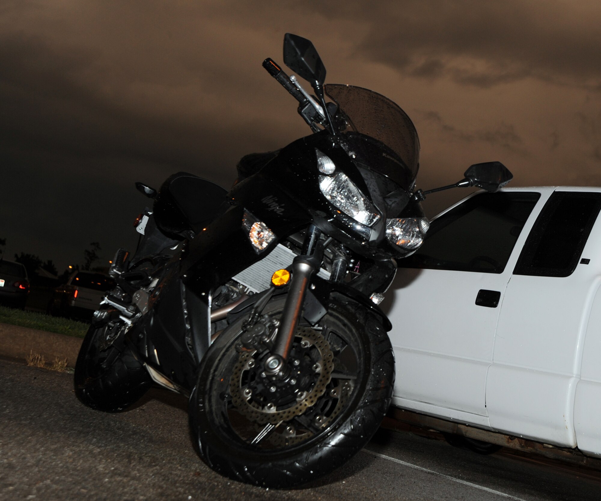 A motorcycle sits outside dorm 350 during a thunderstorm June 8, 2010, McConnell Air Force Base, Kan.  During the summer months, McConnell Airmen may choose to exchange their motor vehicles for motorcycles.  This seasonal trend is one topic being analyzed as part of the 2010 Critical Days of Summer program.   (U.S. Air Force photo/Airman 1st Class Andrea Salazar) 