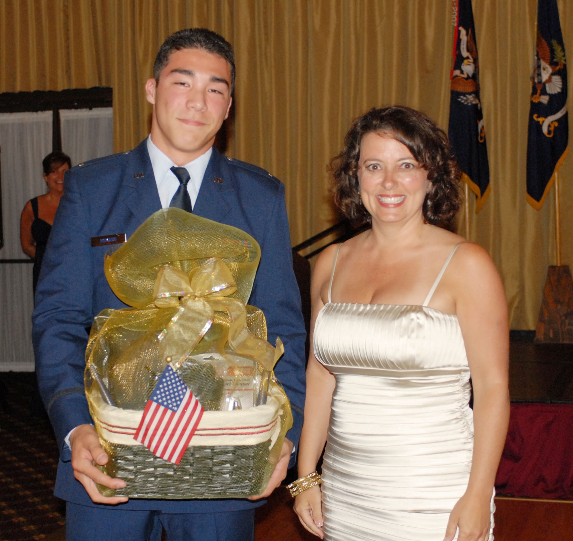 Air Force 2nd Lt. Nick Ramos, brother of Army 1st Lt. Jason Didomenico, 2nd Battalion, 315th Regiment, was the newest military member present at the 72nd Field Artillery Brigade’s annual dining out. He commissioned three weeks prior to the event.  Ellen Vinzant presents him with a gift basket for the honor. (U.S. Army photo/ Sgt. Nicole Dykstra)
