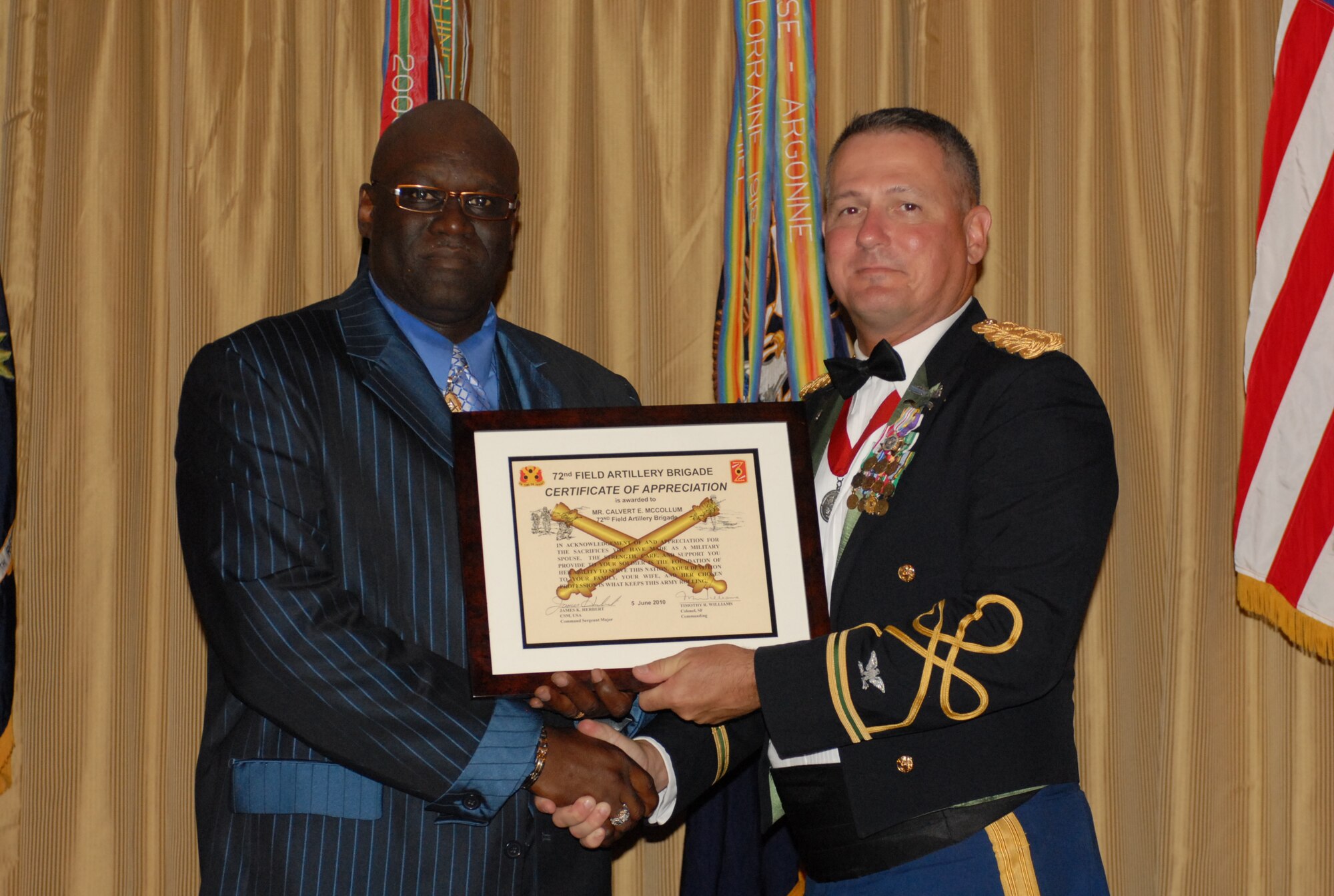 Calvert McCollum, husband of Sgt. 1st Class Marlena McCollum, 72nd Field Artillery Brigade Mobilization and Training Operations, is awarded a certificate of appreciation from Col. Timothy R. Williams, 72nd FAB commander, at the brigade's dining-out celebration Saturday here. McCollum was honored for outstanding support of his wife throughout her career. (U.S. Army photo/ Sgt. Nicole Dykstra)